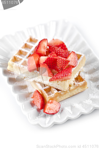 Image of Belgium waffers with sugar powder and strawberries on ceramic pl