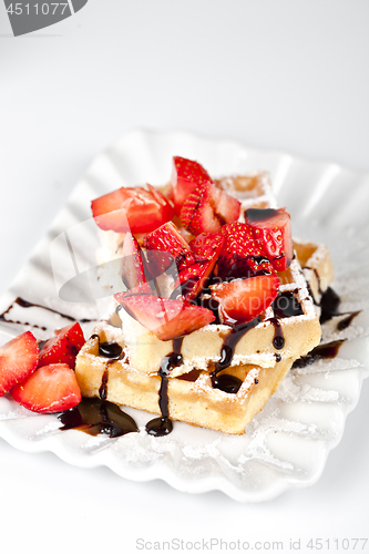 Image of Belgium waffers with sugar powder, strawberries and chocolate on