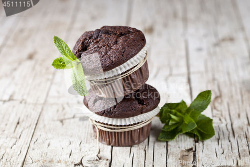 Image of Chocolate dark muffins with mint leaves.