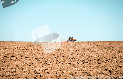 Image of Tractor plowing the land in a spring field