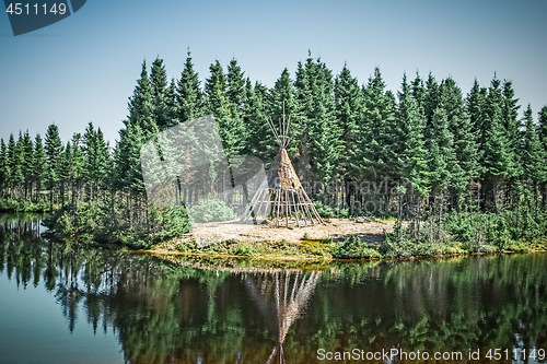 Image of Native American tipi reflecting in the lake