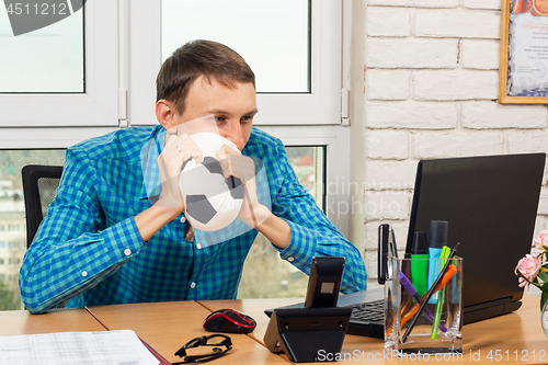 Image of An office worker watches football in the workplace