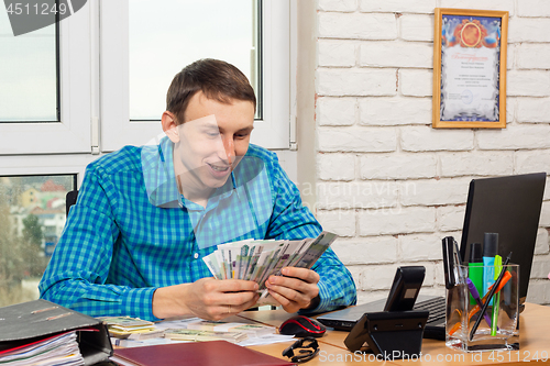 Image of Accountant counts money at the table in the office