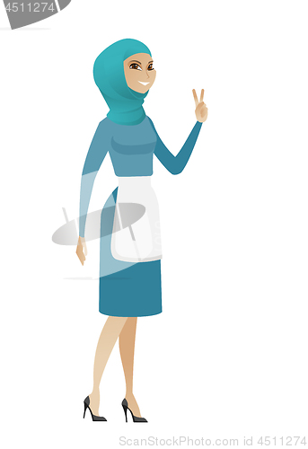 Image of Young muslim cleaner showing victory gesture.