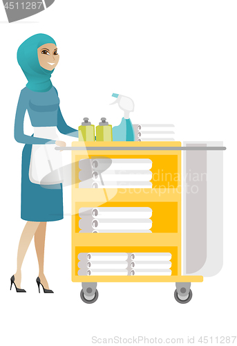 Image of Muslim chambermaid pushing cart with bed clothes.