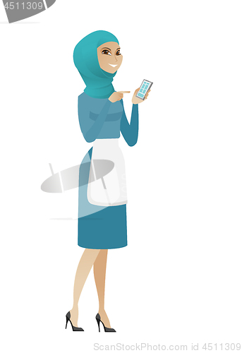 Image of Young muslim cleaner holding a mobile phone.