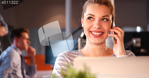 Image of woman using mobile phone in dark office