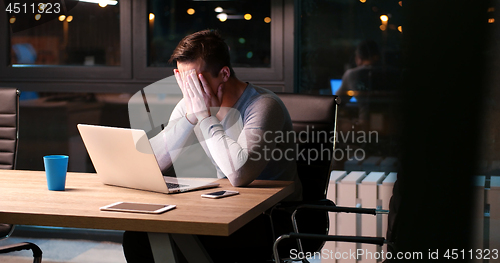 Image of man working on laptop in dark office