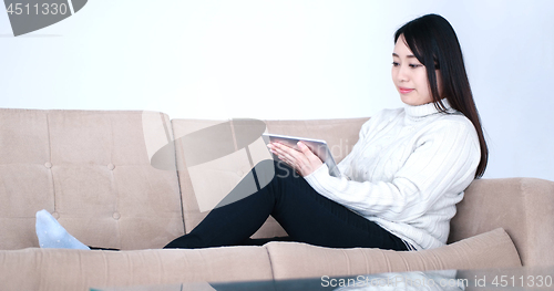 Image of asian woman using Digital Tablet on sofa