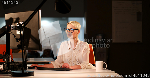 Image of woman working on computer in dark office