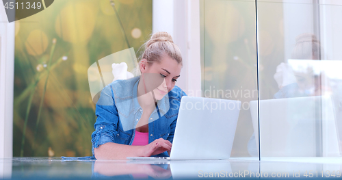 Image of young women using laptop computer on the floor