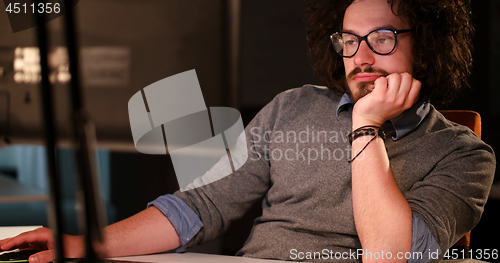 Image of man working on computer in dark office