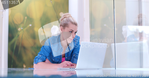 Image of young women using laptop computer on the floor