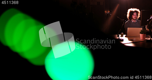 Image of man working on computer in dark office