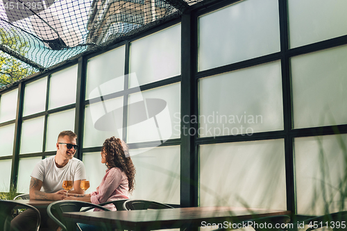 Image of Cheerful couple in cafe having a good time.