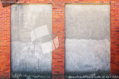 Image of weathered stucco wall and red brick frame around