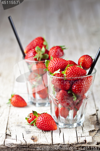 Image of Organic red strawberries in two glasses on rustic wooden backgro