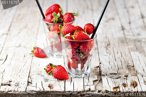 Image of Organic red strawberries in two glasses on rustic wooden backgro