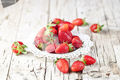 Image of Organic red strawberries on white plate on rustic wooden backgro