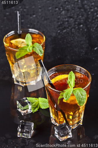 Image of Two glasses with cold traditional iced tea with lemon, mint leav