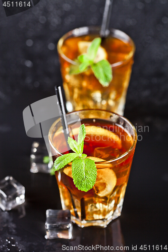 Image of Two glasses with cold traditional iced tea with lemon, mint leav