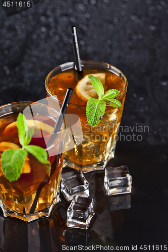 Image of Two glasses with cold traditional iced tea with lemon, mint leav