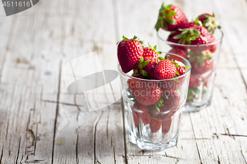 Image of Organic red strawberries in two glasses on rustic wooden backgro