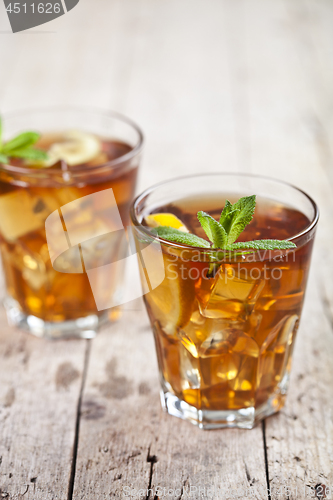 Image of Two glasses with traditional iced tea with lemon, mint leaves an