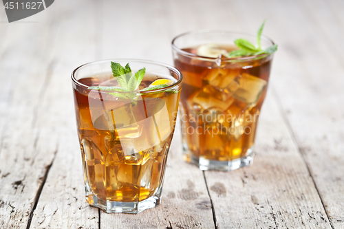 Image of Two glasses with traditional iced tea with lemon, mint leaves an