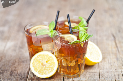 Image of Ttree glasses of traditional iced tea with lemon, mint leaves an