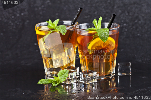 Image of Two glasses with cold traditional iced tea with lemon, mint leav