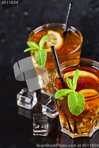 Image of Two glasses with cold traditional iced tea with lemon, mint leav