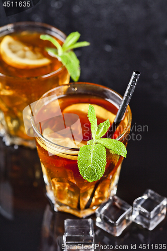 Image of Two glasses with cold traditional iced tea with lemon, mint leav