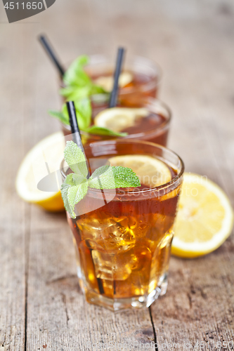 Image of Traditional iced tea with lemon, mint leaves and ice cubes in th