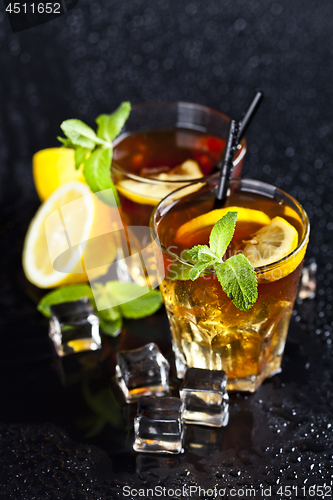 Image of Two glasses with cold traditional iced tea with lemon, mint leav