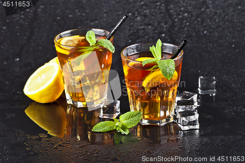 Image of Two glasses with cold traditional iced tea with lemon, mint leav