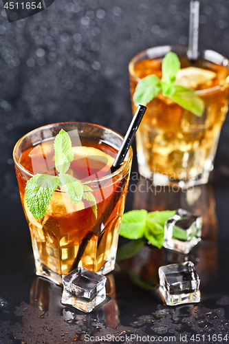 Image of Two glasses with cold traditional iced tea with lemon, mint leav