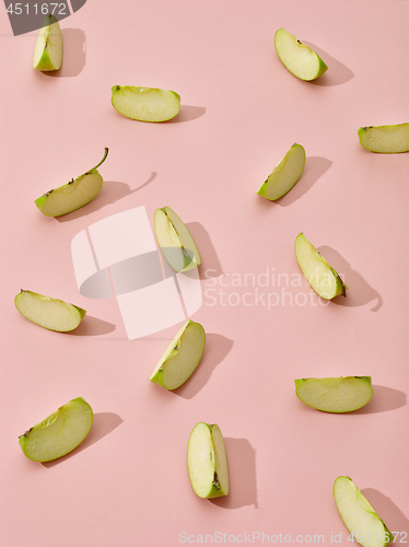 Image of apple pieces on pink background