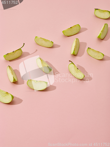 Image of apple pieces on pink background