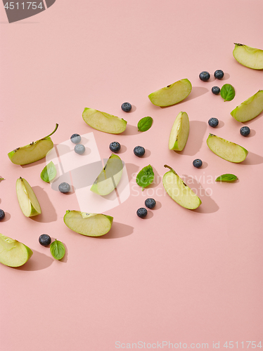 Image of apple pieces, blueberries and green basil leaves