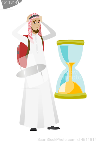 Image of Worried muslim traveler man looking at hourglass.