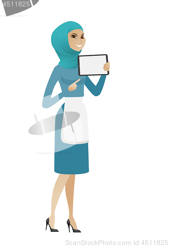 Image of Young muslim cleaner holding tablet computer.