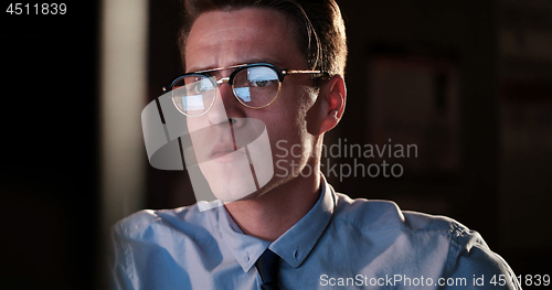 Image of man working on computer in dark office