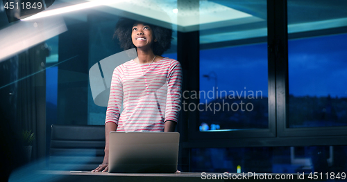 Image of black businesswoman using a laptop in night startup office