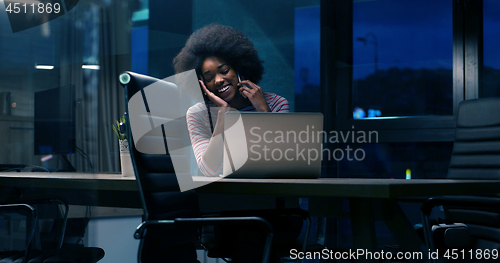 Image of black businesswoman using a laptop in night startup office