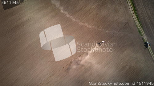 Image of Aerial view the tractor plows the spring field.spring season of agricultural works at farmlands. Drone photograph