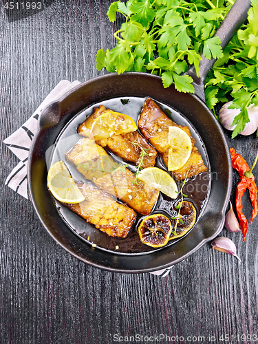 Image of Salmon with sauce in pan on black board top