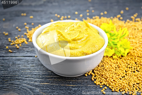 Image of Sauce mustard in bowl with seeds and flower on board