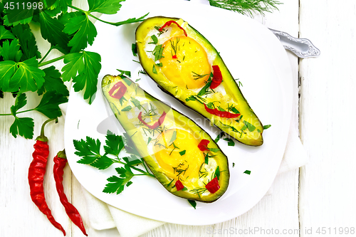 Image of Scrambled eggs with peppers in avocado on board top