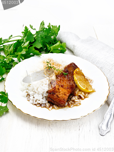 Image of Salmon with sauce and rice in plate on board